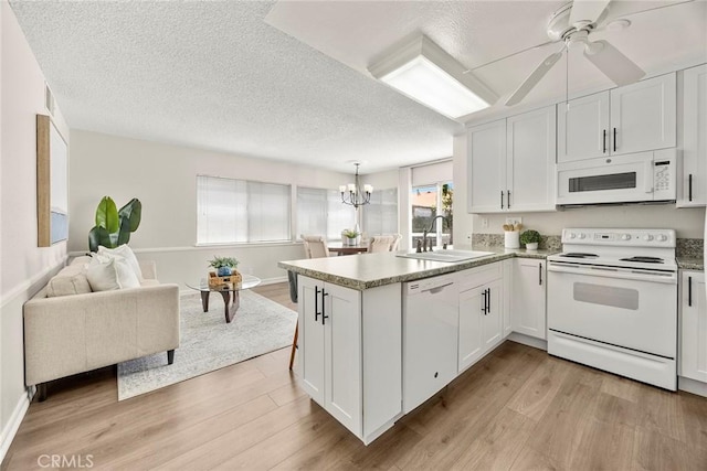 1109 Burns Ave, Santa Ana, CA 92707 - kitchen featuring white appliances, light wood-style floors, a peninsula, white cabinets, and a chandelier