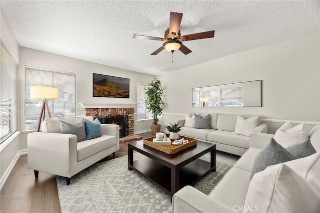 1109 Burns Ave, Santa Ana, CA 92707 - living area with light wood-style floors, plenty of natural light, a textured ceiling, a ceiling fan, and a fireplace