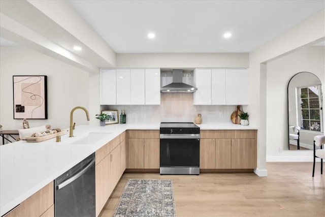 191 Desert Falls Cir, Palm Desert, CA 92211 - kitchen featuring wall chimney range hood, appliances with stainless steel finishes, modern cabinets, light wood-style floors, and light countertops