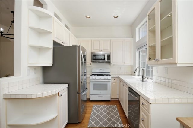 6 Garzoni Aisle, Irvine, CA 92606 - kitchen with open shelves, stainless steel appliances, tile counters, dark wood-style flooring, and glass insert cabinets