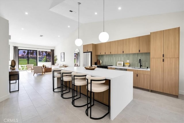 42407 Liolios Dr, Palm Desert, CA 92211 - kitchen with freestanding refrigerator, light countertops, high vaulted ceiling, a breakfast bar area, and decorative backsplash