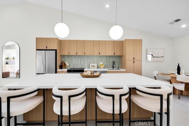42407 Liolios Dr, Palm Desert, CA 92211 - kitchen featuring freestanding refrigerator, light countertops, tasteful backsplash, pendant lighting, and high vaulted ceiling