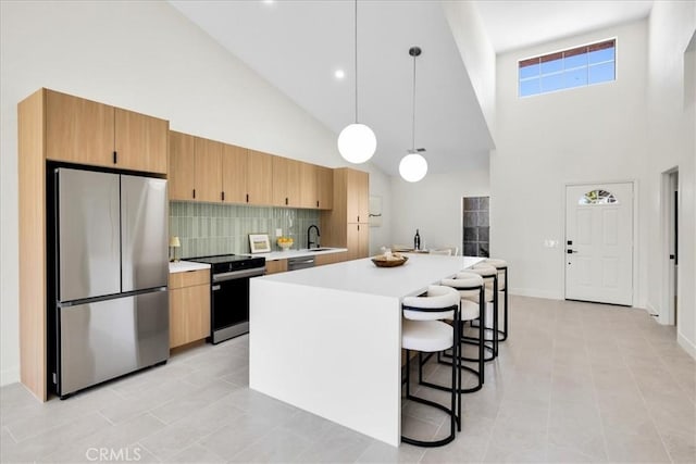 42407 Liolios Dr, Palm Desert, CA 92211 - kitchen with appliances with stainless steel finishes, high vaulted ceiling, light countertops, backsplash, and a center island