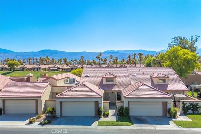 42407 Liolios Dr, Palm Desert, CA 92211 - mediterranean / spanish-style house featuring stucco siding, a mountain view, a residential view, a tiled roof, and an attached garage