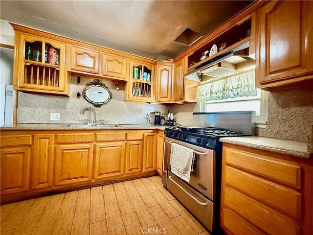 1246 W Mill St, San Bernardino, CA 92410 - kitchen with stainless steel gas range, light wood-style flooring, tasteful backsplash, and under cabinet range hood