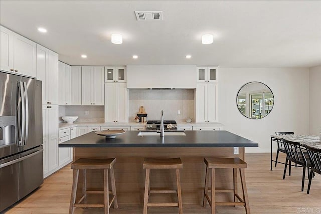 1515 San Pablo Dr, San Marcos, CA 92078 - kitchen with stainless steel fridge with ice dispenser, a kitchen breakfast bar, light wood-style flooring, and recessed lighting