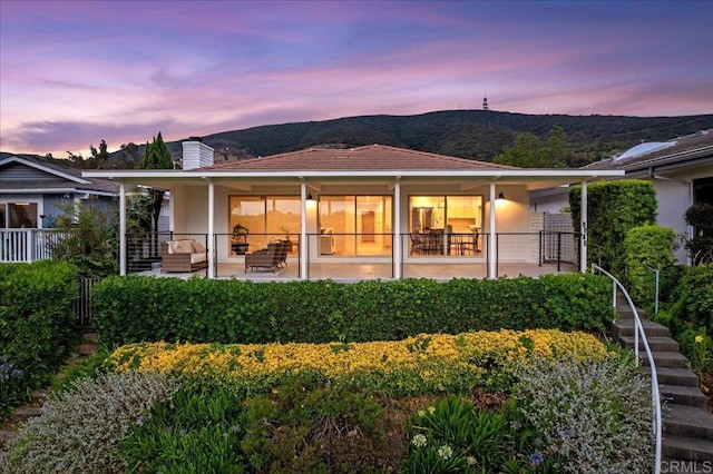 1515 San Pablo Dr, San Marcos, CA 92078 - back of property at dusk with a chimney, a mountain view, and stairway