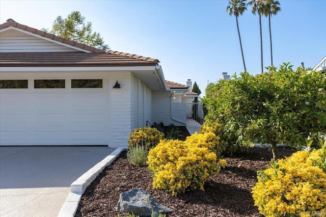 1515 San Pablo Dr, San Marcos, CA 92078 - view of side of home featuring a tiled roof, an attached garage, and brick siding