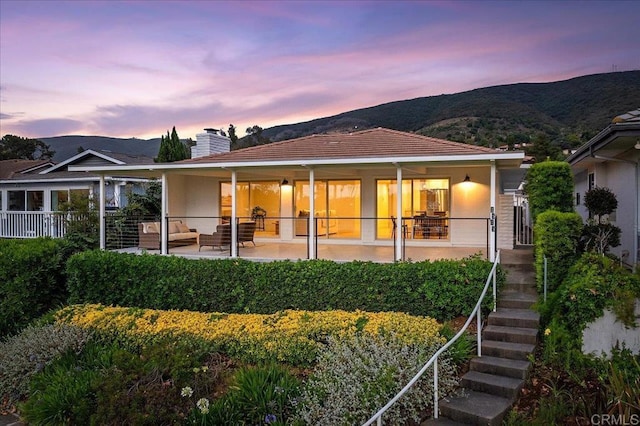 1515 San Pablo Dr, San Marcos, CA 92078 - back of property at dusk featuring a mountain view, a chimney, stairs, and a patio area