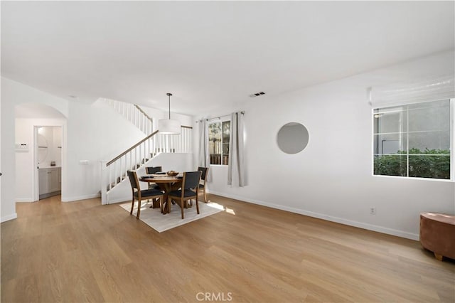 33307 Decada St, Temecula, CA 92592 - dining room featuring stairway, light wood-style flooring, and arched walkways