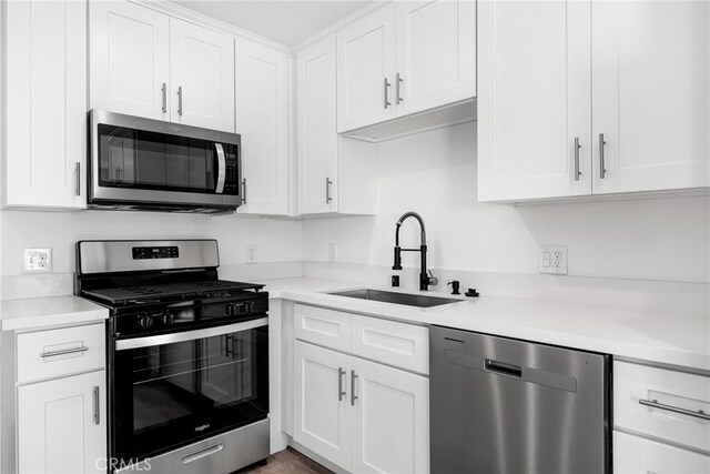 4851 Faculty Ave, Long Beach, CA 90808 - kitchen with stainless steel appliances, white cabinetry, and light countertops