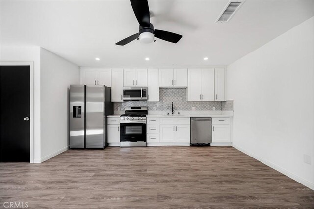 4851 Faculty Ave, Long Beach, CA 90808 - kitchen featuring appliances with stainless steel finishes, backsplash, white cabinets, light countertops, and ceiling fan