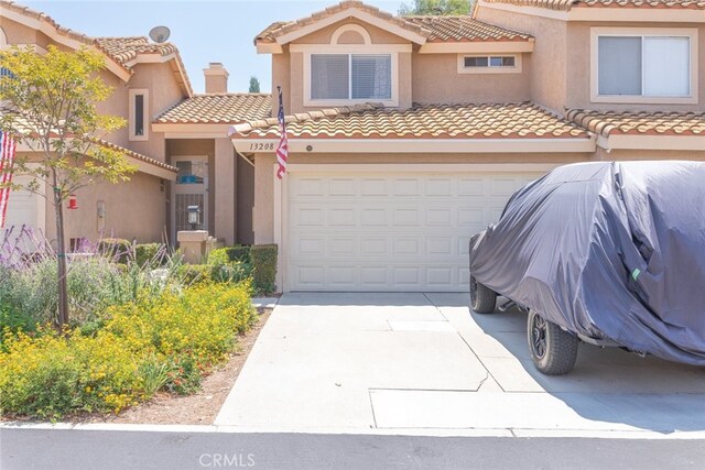13208 Setting Sun Ct, Chino Hills, CA 91709 - view of front of house featuring a tiled roof, stucco siding, an attached garage, and driveway