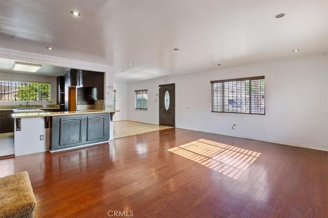 347 E 97th St, Los Angeles, CA 90003 - unfurnished living room featuring healthy amount of natural light, light wood-type flooring, and recessed lighting