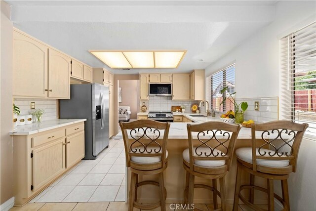 37826 Sweetbrush St, Palmdale, CA 93552 - kitchen with stainless steel appliances, a peninsula, backsplash, and light countertops