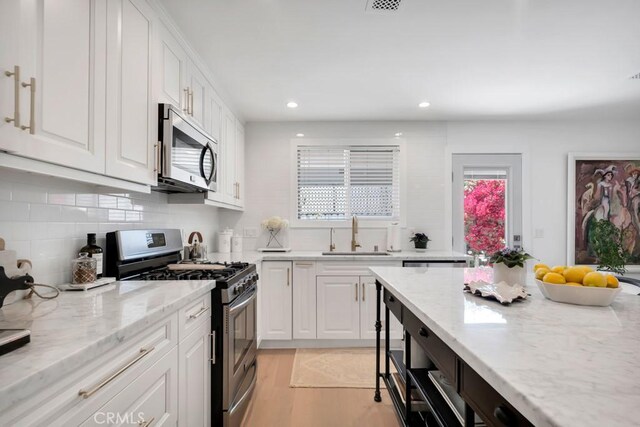 23451 Friar St, Woodland Hills, CA 91367 - kitchen with appliances with stainless steel finishes, white cabinets, recessed lighting, tasteful backsplash, and plenty of natural light