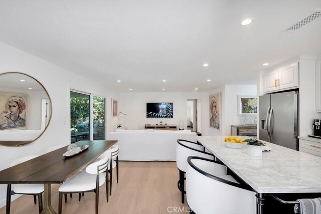 23451 Friar St, Woodland Hills, CA 91367 - kitchen featuring stainless steel fridge with ice dispenser, white cabinets, light wood finished floors, recessed lighting, and a center island