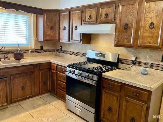 2720 Baylor St, Bakersfield, CA 93305 - kitchen with gas range, custom exhaust hood, light tile patterned flooring, and backsplash