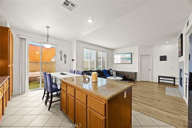 1711 Lordsburg Ct, La Verne, CA 91750 - kitchen with light tile patterned flooring, a kitchen island, brown cabinets, recessed lighting, and open floor plan