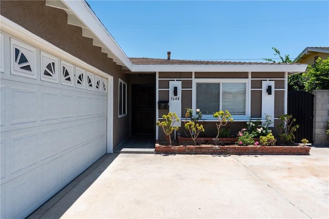 3644 Ardilla Ave, Baldwin Park, CA 91706 - property entrance featuring an attached garage, concrete driveway, and stucco siding