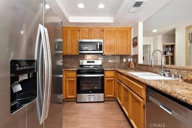 1413 Daisy St, Upland, CA 91784 - kitchen featuring stainless steel appliances, light wood-style floors, backsplash, light stone counters, and a raised ceiling