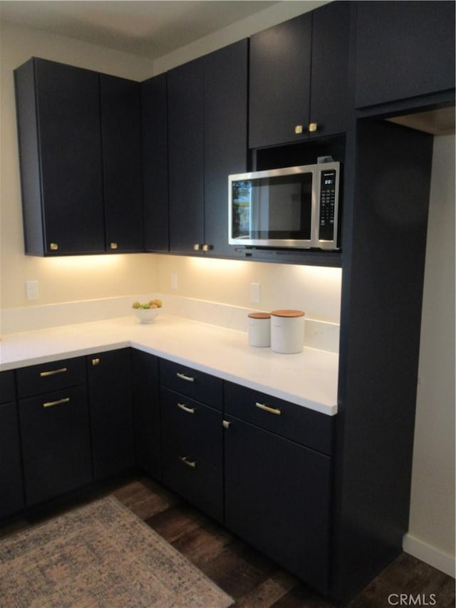 7906 Curbaril Ave, Atascadero, CA 93422 - kitchen with stainless steel microwave, dark wood-type flooring, dark cabinets, and light countertops