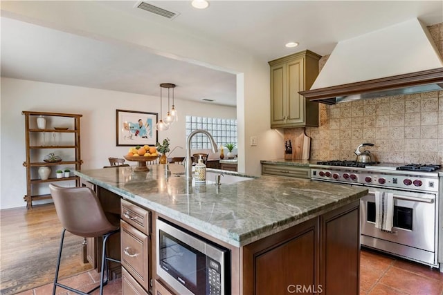 1335 Crestview Ave, Seal Beach, CA 90740 - kitchen with stainless steel appliances, custom range hood, a kitchen island with sink, a kitchen bar, and backsplash