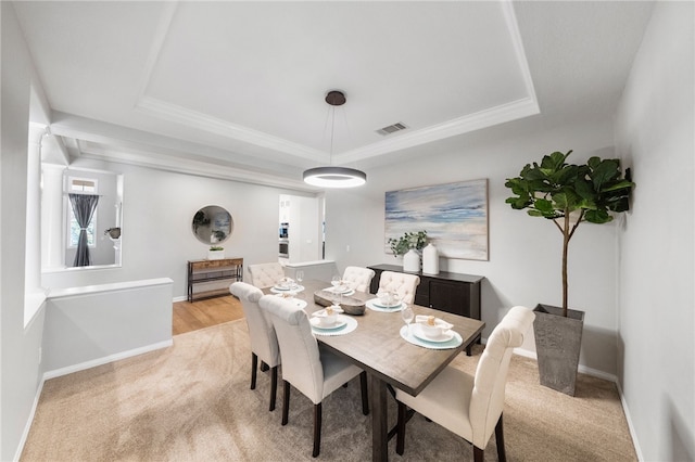 12554 Tejas Ct, Rancho Cucamonga, CA 91739 - dining room featuring a tray ceiling, light colored carpet, and crown molding