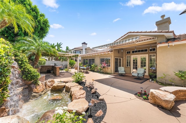 12554 Tejas Ct, Rancho Cucamonga, CA 91739 - back of property featuring french doors, a small pond, stucco siding, and a patio area