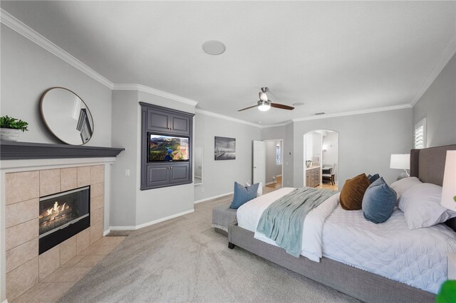 12554 Tejas Ct, Rancho Cucamonga, CA 91739 - bedroom featuring arched walkways, crown molding, light carpet, a tile fireplace, and ceiling fan
