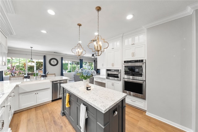 12554 Tejas Ct, Rancho Cucamonga, CA 91739 - kitchen with stainless steel appliances, white cabinets, crown molding, a chandelier, and a center island