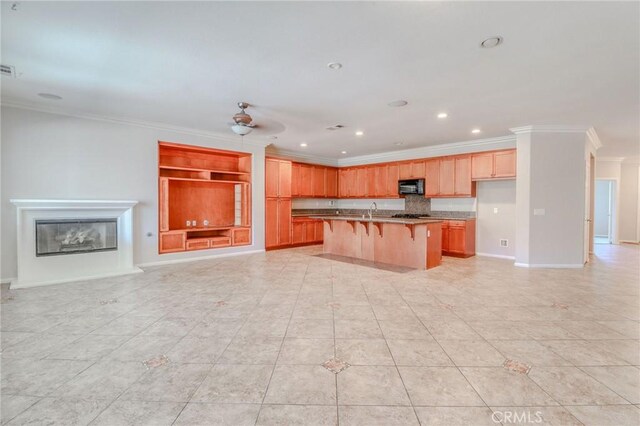 26946 Shelter Cove Ct, Menifee, CA 92585 - kitchen featuring black microwave, ornamental molding, open floor plan, a kitchen bar, and light tile patterned floors