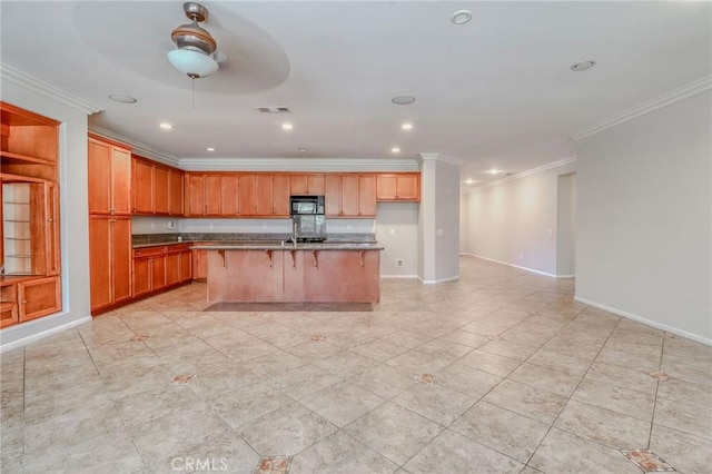 26946 Shelter Cove Ct, Menifee, CA 92585 - kitchen with black microwave, crown molding, a center island with sink, a kitchen breakfast bar, and recessed lighting