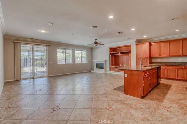 26946 Shelter Cove Ct, Menifee, CA 92585 - kitchen featuring crown molding, ceiling fan, a center island with sink, recessed lighting, and a glass covered fireplace