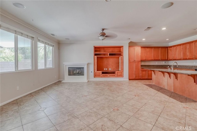 26946 Shelter Cove Ct, Menifee, CA 92585 - kitchen featuring a breakfast bar area, light stone counters, light tile patterned floors, ceiling fan, and crown molding