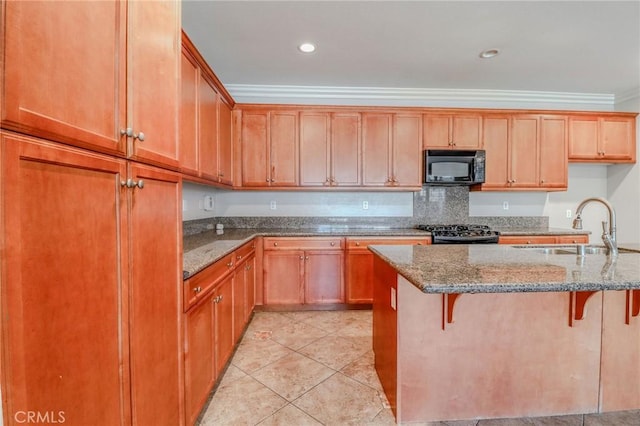 26946 Shelter Cove Ct, Menifee, CA 92585 - kitchen with black microwave, stone counters, stove, ornamental molding, and a kitchen bar