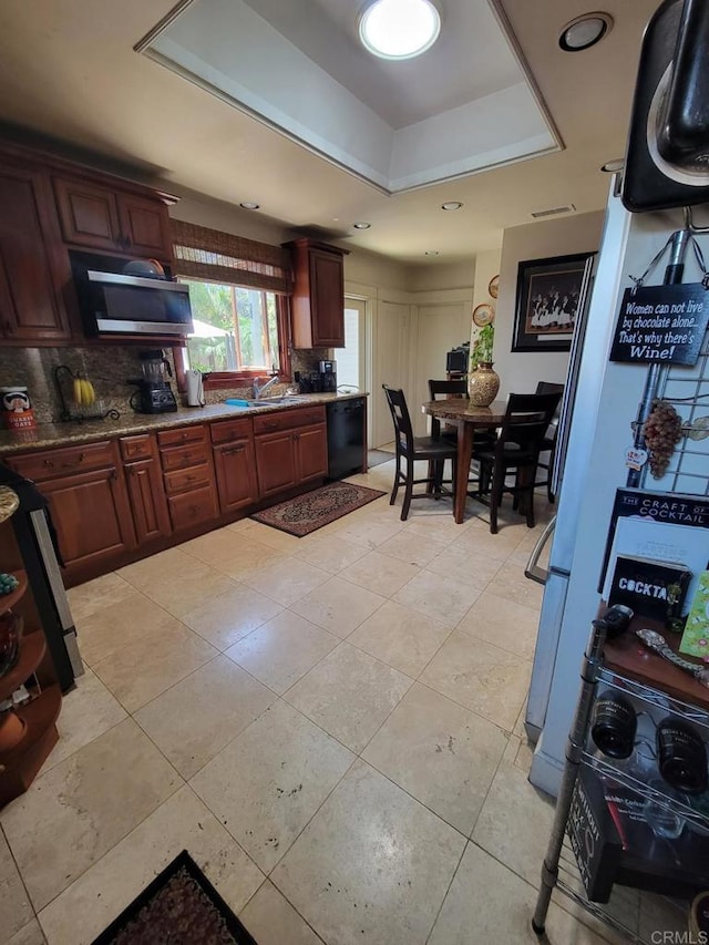 1320 Granada Ave, San Diego, CA 92102 - kitchen featuring stainless steel microwave, dishwasher, a tray ceiling, backsplash, and freestanding refrigerator