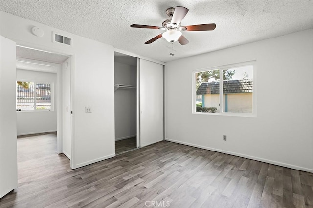 2536 Bryn Mawr Ln, Riverside, CA 92507 - unfurnished bedroom featuring wood finished floors, multiple windows, a closet, a textured ceiling, and ceiling fan