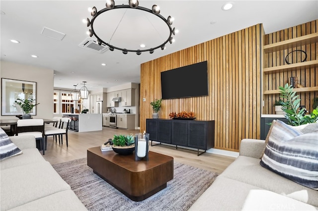 19011 Main St Unit 113, Huntington Beach, CA 92648 - living room with light wood-style flooring, an accent wall, recessed lighting, and a chandelier