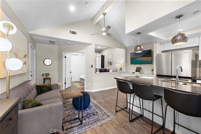 1046 Calle Del Cerro Unit 412, San Clemente, CA 92672 - kitchen with freestanding refrigerator, a breakfast bar, wood finished floors, ceiling fan, and pendant lighting