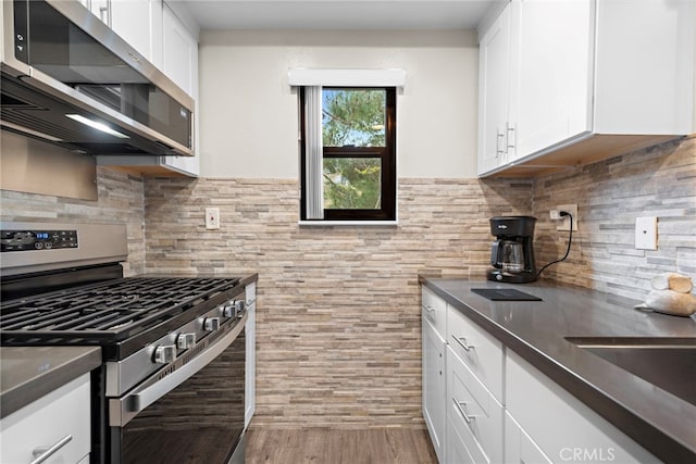 1046 Calle Del Cerro Unit 412, San Clemente, CA 92672 - kitchen with appliances with stainless steel finishes, white cabinetry, dark countertops, and wood finished floors