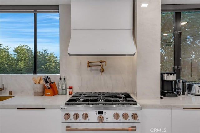 15125 Rayneta Dr, Sherman Oaks, CA 91403 - kitchen with range, exhaust hood, backsplash, and white cabinetry