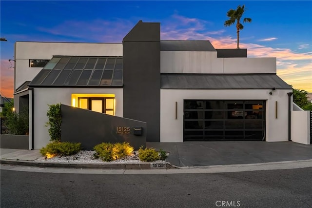 15125 Rayneta Dr, Sherman Oaks, CA 91403 - view of front of house with a standing seam roof, a garage, a metal roof, stucco siding, and driveway
