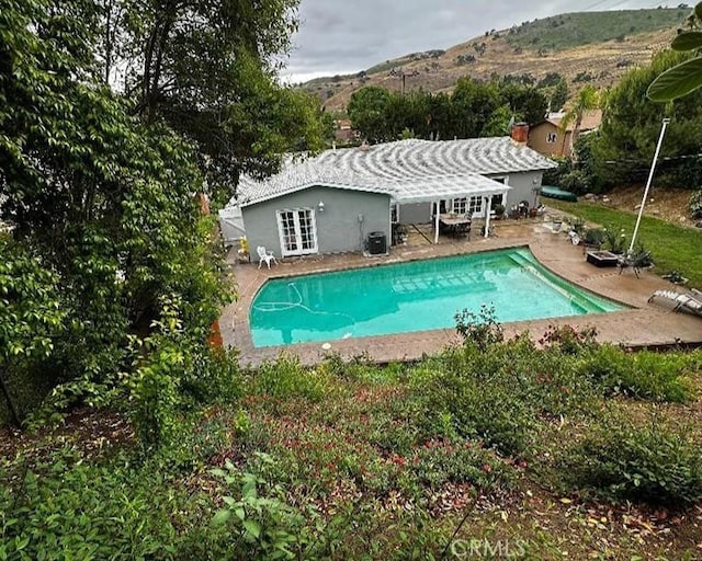 26261 Veva Way, Calabasas, CA 91302 - outdoor pool with french doors, a patio area, and a mountain view