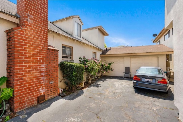 1900 Vanderbilt Ln, Redondo Beach, CA 90278 - view of home's exterior with a garage, asphalt driveway, a chimney, and stucco siding
