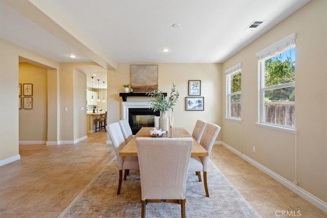 839 Chukar St, Arroyo Grande, CA 93420 - dining space featuring a glass covered fireplace, recessed lighting, light tile patterned flooring, and arched walkways