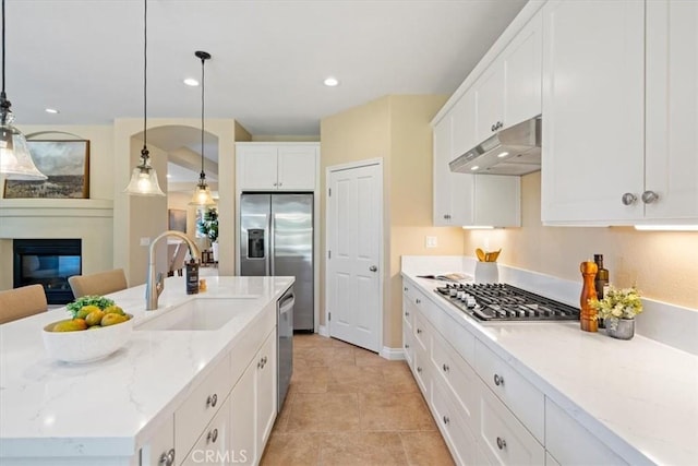 839 Chukar St, Arroyo Grande, CA 93420 - kitchen featuring stainless steel appliances, under cabinet range hood, white cabinetry, a glass covered fireplace, and light stone countertops