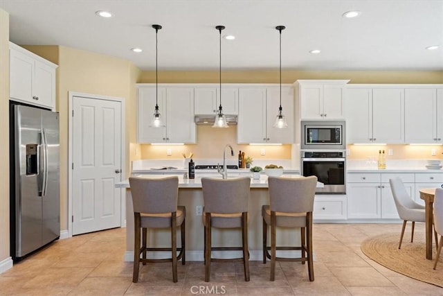 839 Chukar St, Arroyo Grande, CA 93420 - kitchen with stainless steel appliances, white cabinets, light countertops, hanging light fixtures, and a center island with sink