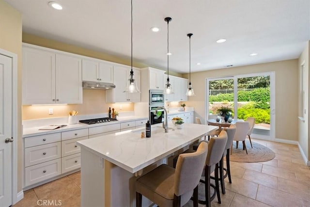839 Chukar St, Arroyo Grande, CA 93420 - kitchen with stainless steel appliances, under cabinet range hood, an island with sink, white cabinets, and a kitchen breakfast bar