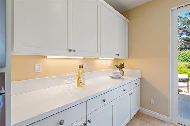 839 Chukar St, Arroyo Grande, CA 93420 - kitchen with plenty of natural light, white cabinetry, light stone countertops, and light tile patterned floors